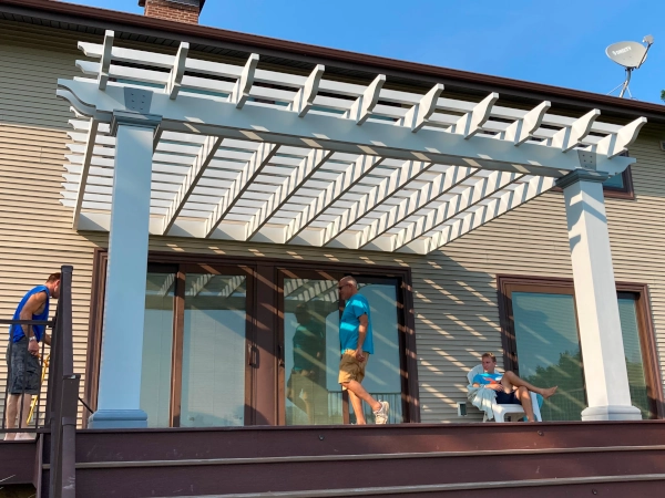 A fiberglass pergola attached to house and mounted on deck