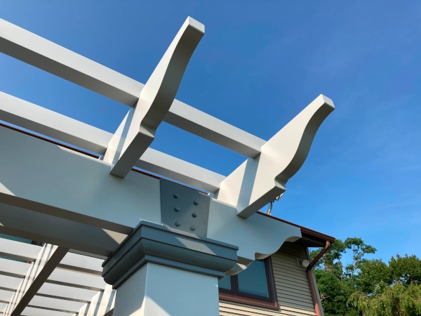 A fiberglass pergola attached to house and mounted on deck