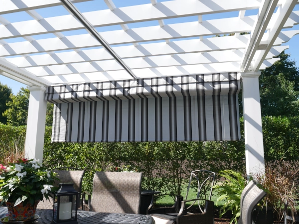 A fiberglass pergola with an overhead shade and a roll up shade